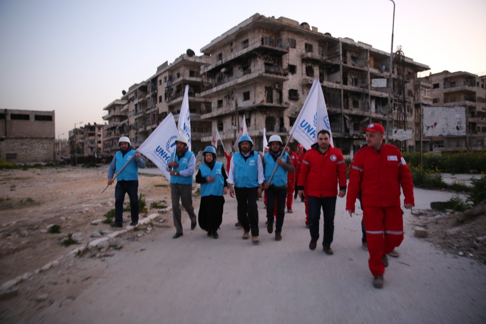 A joint UNHCR and Syrian Arab Red Crescent mission moving through a war-damaged neighbourhood.