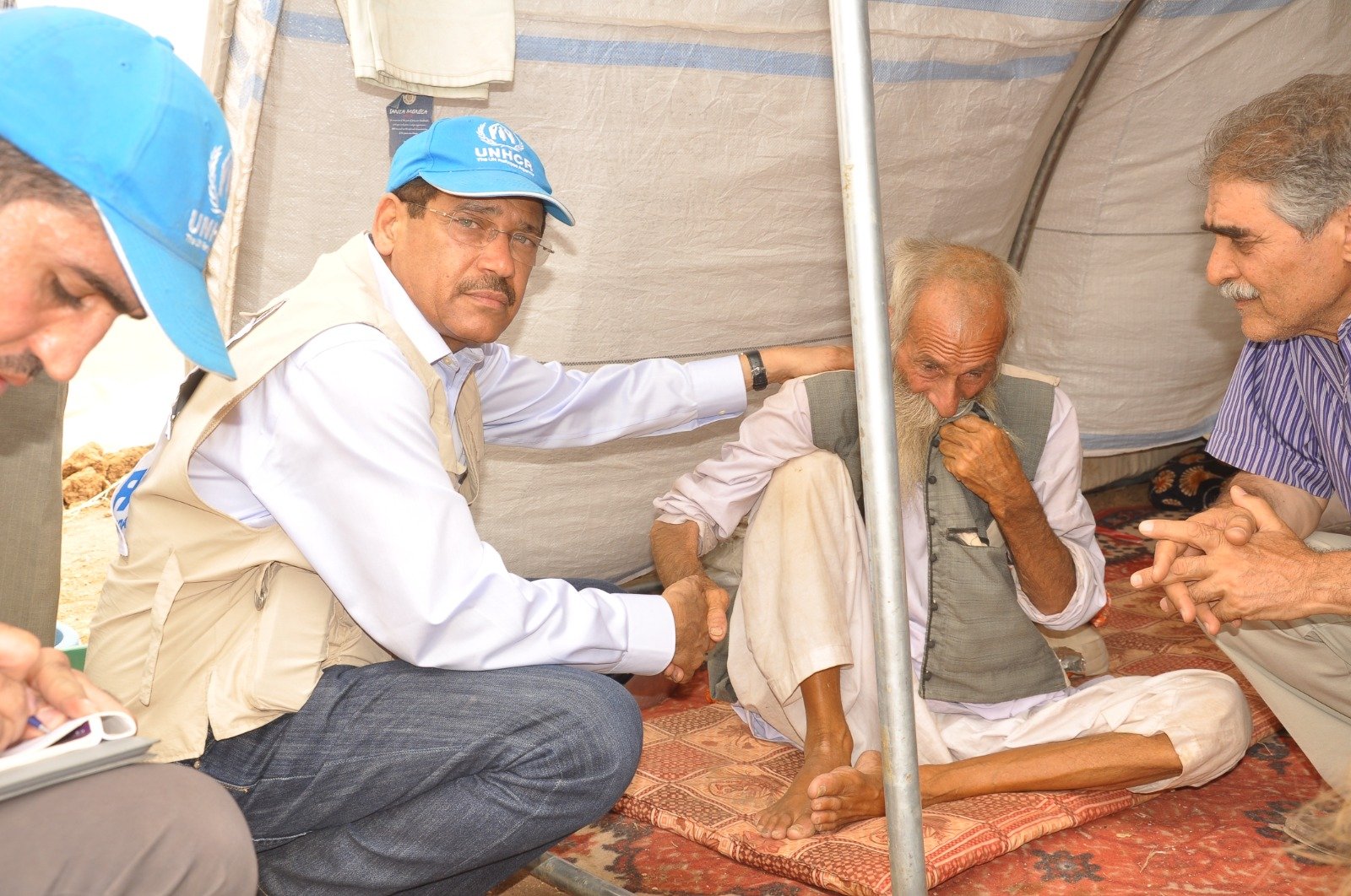 Listening to an elderly refugee during a protection consultation in the field.