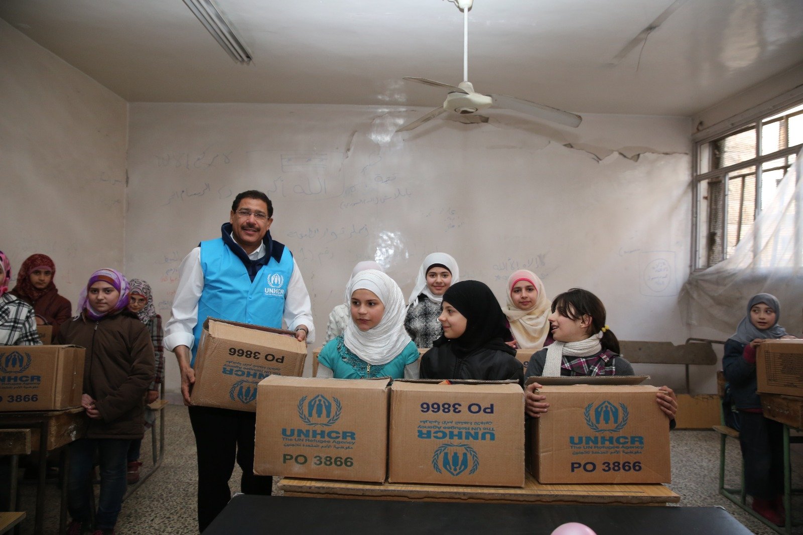 Distributing UNHCR relief and school supplies to displaced children.