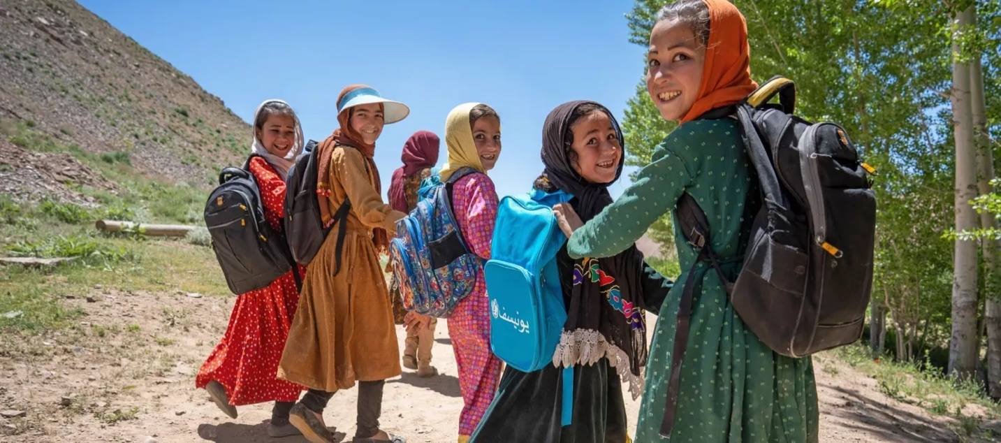 Children walking to school with United Nations-supplied bags