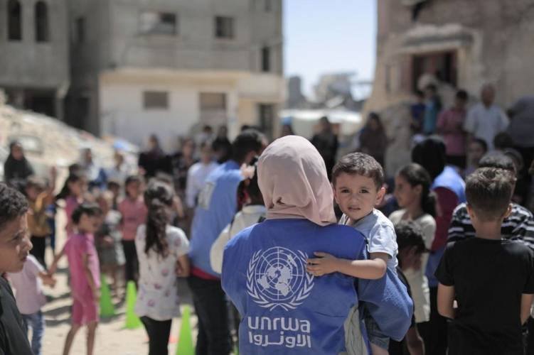 A humanitarian worker carrying a child amid displacement